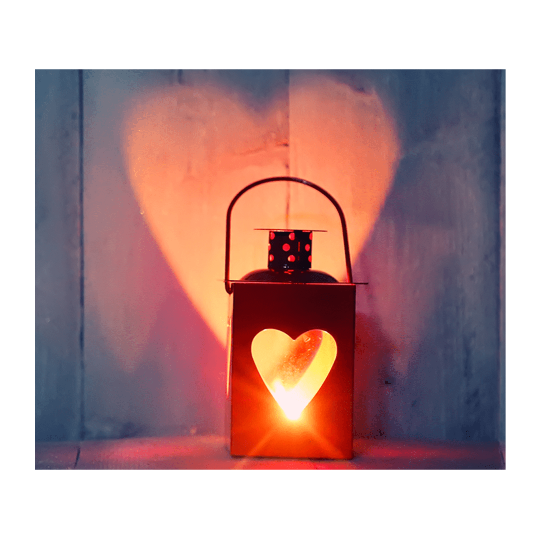 Rustic lantern with a heart-shaped cutout casting a warm glow on a wooden background, symbolizing love and warmth.